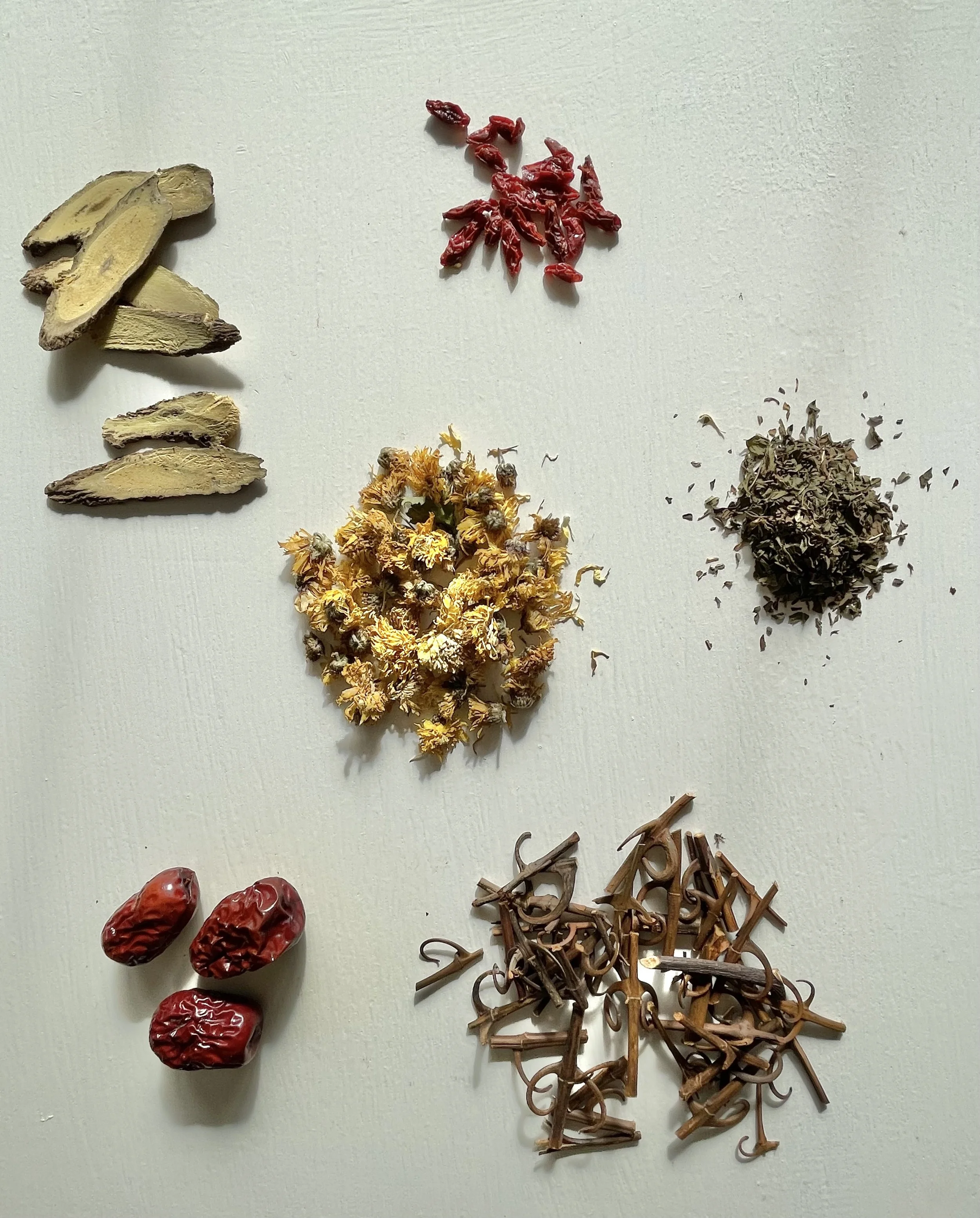 Traditional herbs arranged with acupuncture tools.
